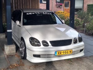 A white car parked under a covered garage.